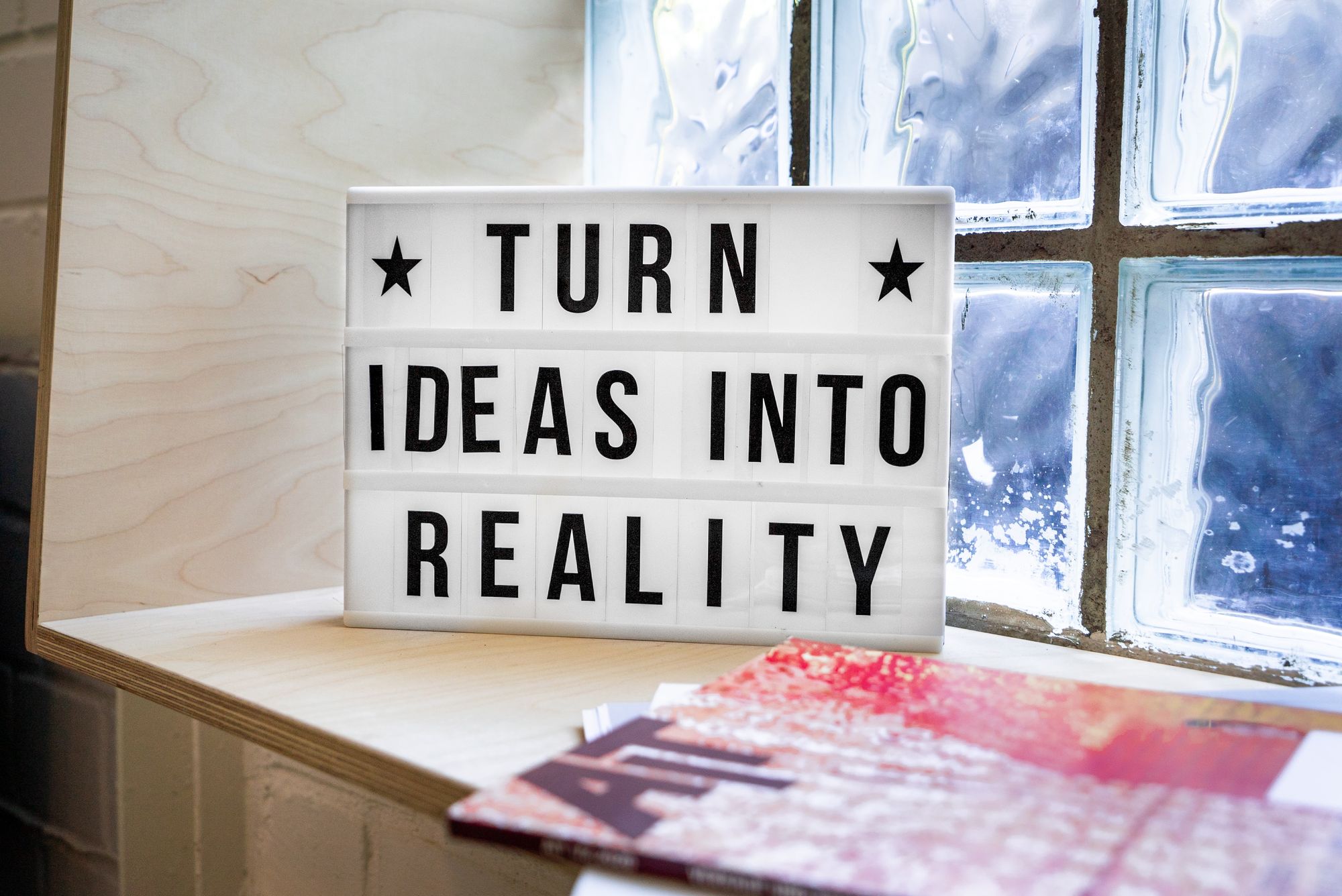 Image of a sign in a window that says 'Turn ideas into reality.'